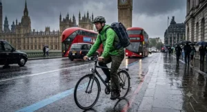 Cyclist carrying the best waterproof daypack while commuting along wet London streets in torrential rain.